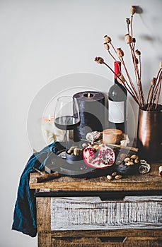 Red wine and snacks over rustic wooden kitchen counter