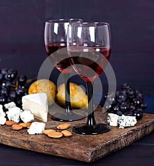 Red wine and snacks. Wine, grapes, cheese, nuts, olives. Romantic evening, still life.