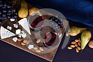 Red wine and snacks. Wine, grapes, cheese, nuts, olives. Romantic evening, still life.