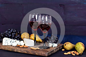 Red wine and snacks. Wine, grapes, cheese, nuts, olives. Romantic evening, still life.
