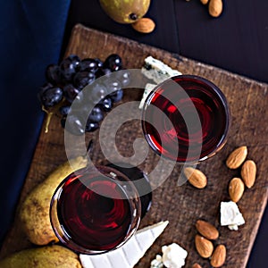 Red wine and snacks. Wine, grapes, cheese, nuts, olives. Romantic evening, still life.