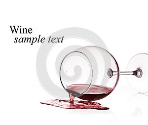 Red wine spilled from glass over white background