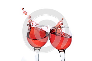 Red wine splash in two glasses, isolated on a white