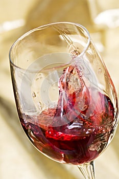 Red wine is splashing in glass