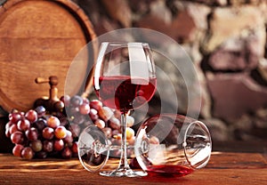 Red wine.Still life with two glasses of red wine, grapes and barrel.Selective focus.Copy space
