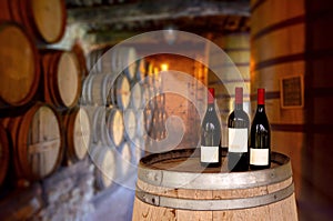 Red wine tasting in an old wine cellar with wooden wine barrels in a winery