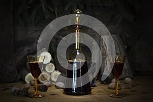 Red Wine Vintage Bottle and Glasses Resting On Wooden Table Against Christmas Background With Wood logs and Pine Branches