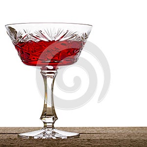 Red wine in vintage crystal glass on a white background