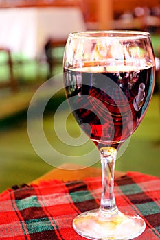 Red wine in wineglass on the table with a tablecloth in a restaurant. loneliness.