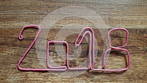 the red wire forms the number 2018 on a wooden background