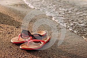 Red women`s beach flip-flops for the sand on the beach