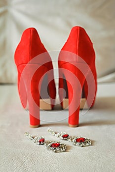 Red women`s shoes stand on the windowsill, wedding, boutonniere photo