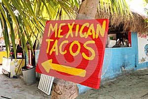 Red wood sign that says Mexican Tacos