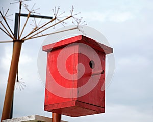 Red wooden bird house in the city