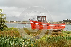 Red wooden boat docked ashore