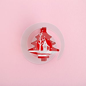 Red wooden Christmas and New Year decoration in the form of Christmas tree on a pink background.