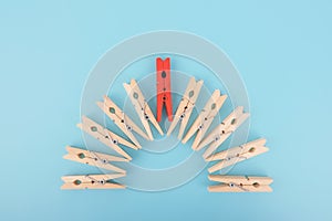 Red wooden clothespin - standing out from the crowd, concept of difference