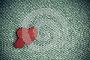 Red wooden decorative hearts on gray cloth background.