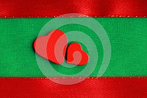 Red wooden decorative hearts on green cloth background