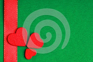 Red wooden decorative hearts on green cloth background