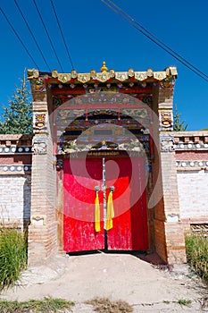 Red wooden door with metal door ring in Tibetan Buddhist monastery Arou Da Temple in Qinghai China