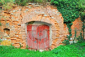 Red wooden door to an old wine cellar