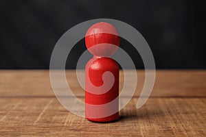 Red wooden figure on a wooden table