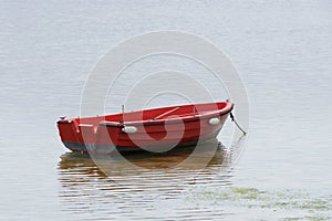 Red wooden fishing boat moored at the sea