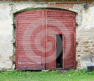 Red wooden gate of the old rustic shed