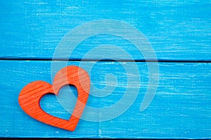 Red wooden heart on a blue background, Valentine`s Day. concept of love