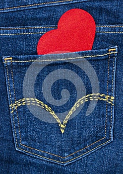 Red wooden heart coming out of denim jeans pocket