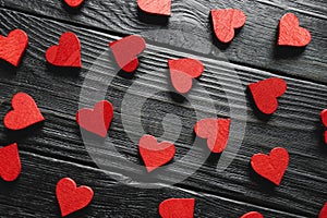 Red wooden hearts on black wooden background
