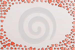 Red wooden hearts on a white table with place for text. Background for greeting card or congratulations on Valentine`s Day. Copy