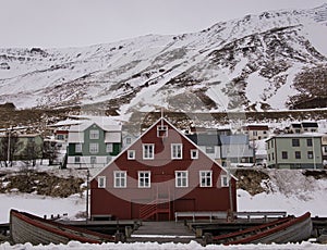 Red wooden house in front of snow covered mountain