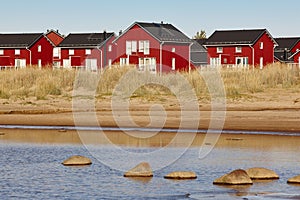 Red wooden houses near Marjaniemi beach, Hailuoto island. Finland.