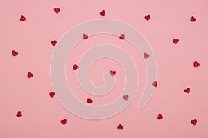 Red wooden love hearts on a pink pastel background