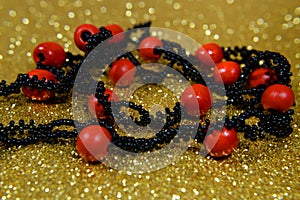 Red wooden necklace black on gold blur background