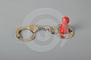 Red wooden people of figure with handcuff locked. Handcuffed convict, law offender and justice concept