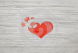 Red wooden puzzle heart on grey background