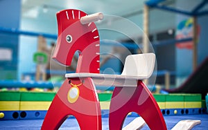 Red Wooden Rocking Horse in a Indoor Playground