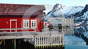 Red wooden Rorbu cabins in the in the Lofoten Islands. Traditional fishing village, with red rorbu houses against snowy