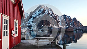 Red wooden Rorbu cabins in the in the Lofoten Islands. Traditional fishing village, with red rorbu houses against snowy