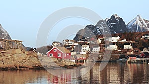 Red wooden Rorbu cabins in the in the Lofoten Islands. Traditional fishing village, with red rorbu houses against snowy