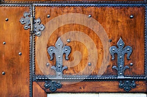 Red wooden surface with ancient metal hinges