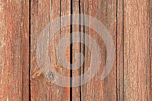 Red wooden surface, backdrop, background. Front view of an old wooden fence for inscription. Pink wood fencing