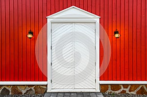 Red wooden wall and white doors with two lamps