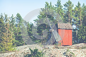 Red wooden windmill in a old vintage rural landscape at Aland islands, Finland. Jan Karlsgarden open air museum. Ethnographic park