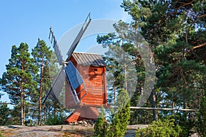 Red wooden windmill in a old vintage rural landscape at Aland islands, Finland. Jan Karlsgarden open air museum. Ethnographic park