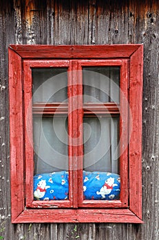 Red wooden window on a rustic house