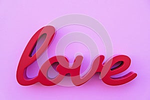 Red wooden word love on pink background, top view